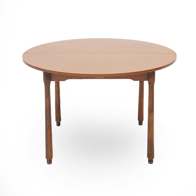 Italian-made dining table produced in the 1960s. Circular veneered wood top with the possibility of extension placed under...