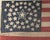 Paint-printed flag on cotton, 8 x 13 in. Double medallion pattern with haloed central star, flanked by three stars in each...