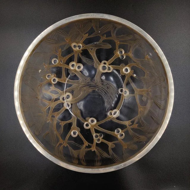 A rare early piece by René Lalique with a sophisticated mistletoe design and patterned silver rim. The raised mistletoes...