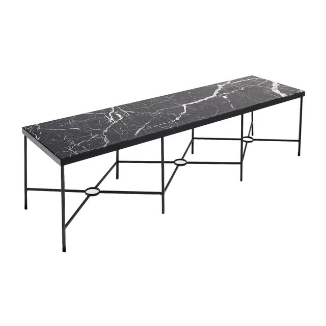 Coffee table from Franc. The structure of the table is steel with three x-shaped stretchers. The top is a striking black...