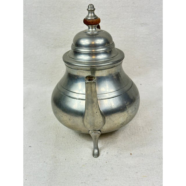 Vintage Colonial Williamsburg Stieff pewter teapot featuring a walnut handle and three footed scroll legs. This is a pre-...