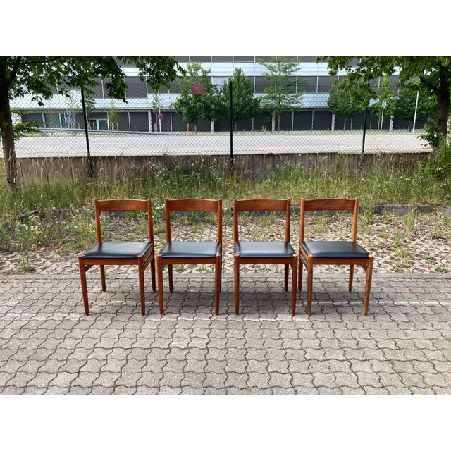 Elegant Mid-Century dining chair crafted from solid teak with a beautifully oiled finish. The seat is upholstered in black...