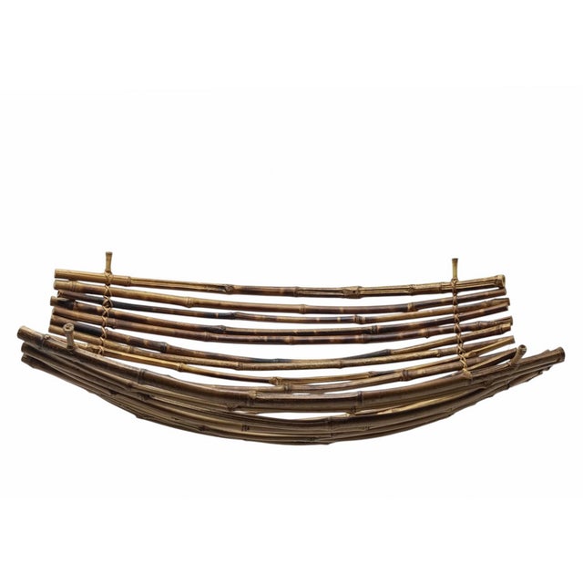 An elegant centrepiece, handcrafted from strips of natural bamboo, featuring a striking ‘boat-shaped’ design. The...