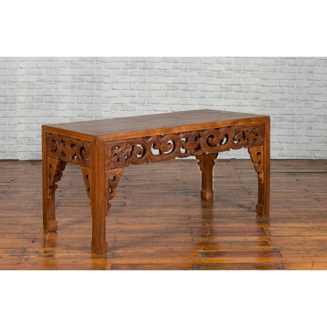 A Chinese antique low side table from the early 20th century, with cloudy carved apron. Created in China during the early...