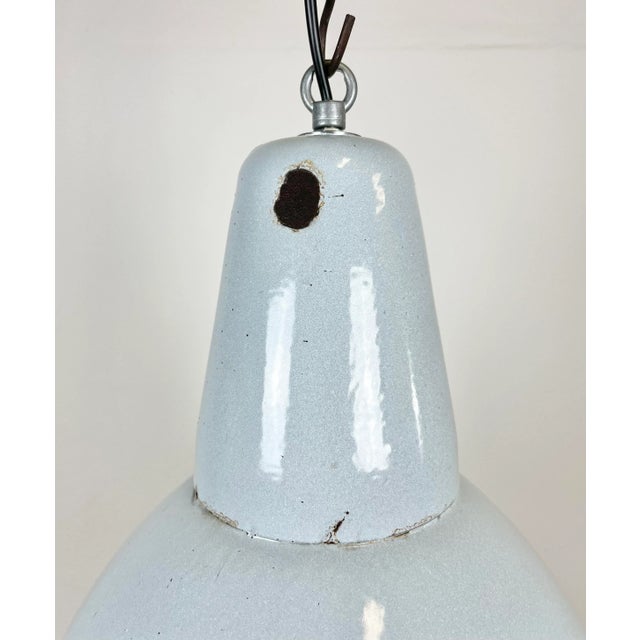 Industrial grey enamel pendant light made by Polam Wilkasy in Poland during the 1960s. White enamel inside the shade. Iron...