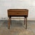 A vintage Danish teak nightstand with a compact raised form, single drawer, and lower string shelf. The piece has a simple...