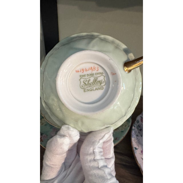 A stunning example of the coveted "Melody" chintz pattern. This trio includes a fluted teacup with an interior floral...