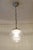 Art Deco lamp, circa 1920. Nickel-plated brass body, suspended by a chain. Step-shaped, grooved clear glass shade. The...