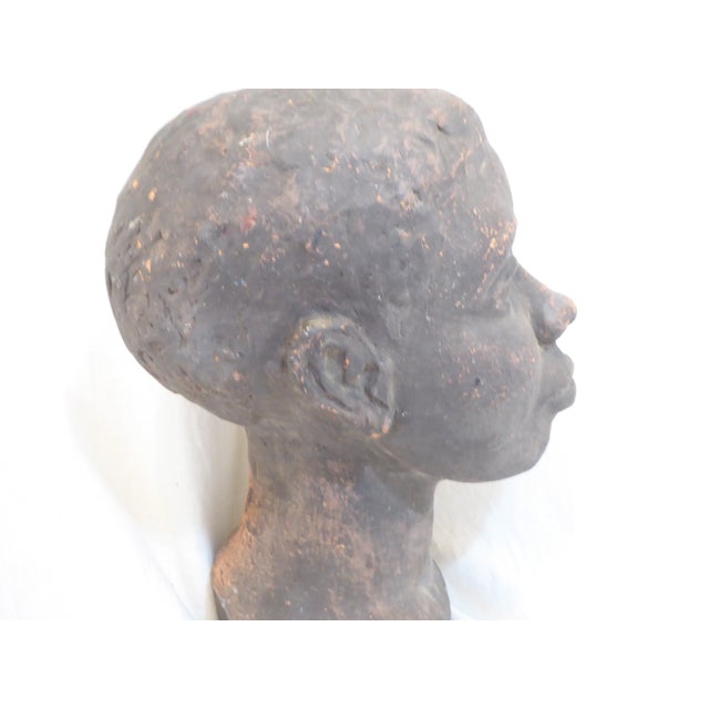 This sculpted bust of a woman is an unglazed, fired ceramic.