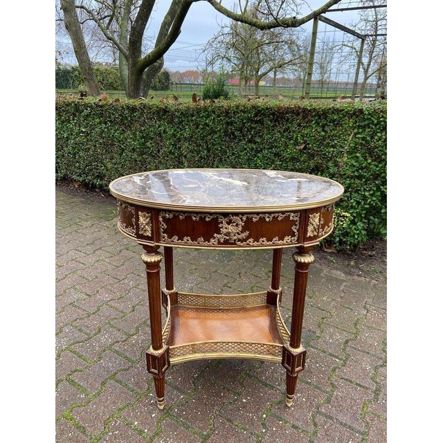 This elegant late 20th-century French Louis XVI–style side table combines richly toned mahogany with finely detailed...