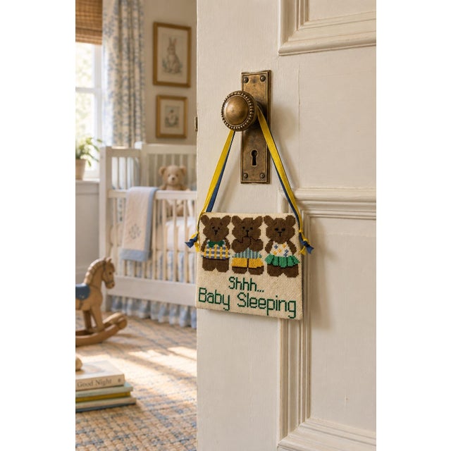 Charming handmade needlepoint nursery door sign featuring three teddy bears in colorful outfits above the hand-stitched...