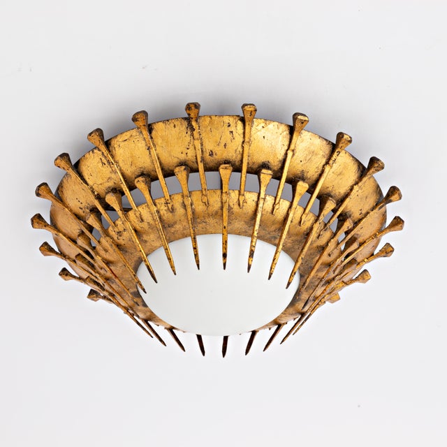 Hand hammered Spanish gilded iron flush mount, made around the 1950s. This brutalist styled light is in great vintage...