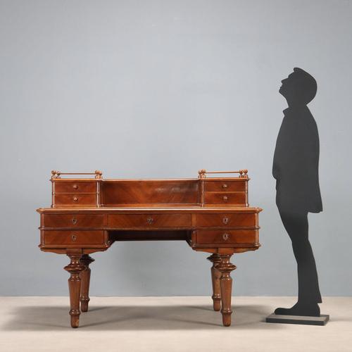 Walnut desk. Top with leather insert, five drawers on the front, four turned tapered legs. Backsplash with a pair of...