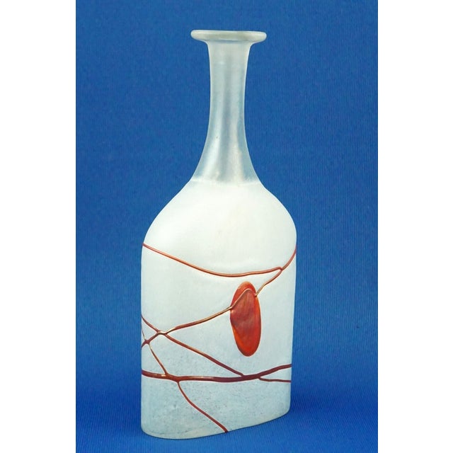 Item : A vase or bottle, entirely hand-blown and crafted from opaque white, acid-treated glass, decorated with ruby ​​red...