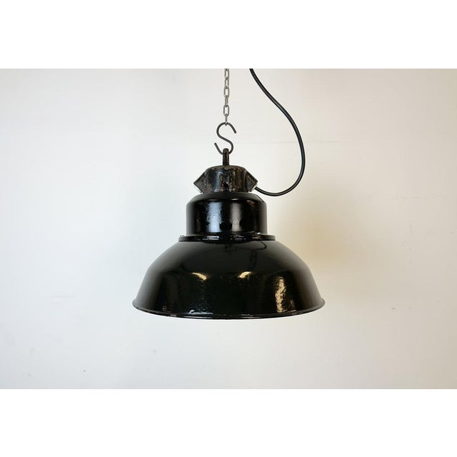 Industrial black enamel pendant light made by Elektrosvit in former Czechoslovakia during the 1960s. White enamel inside...