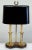 Vintage French Bouillotte style lamp with a wood base and brass overlay. Two candle sticks topped with black oval shade....