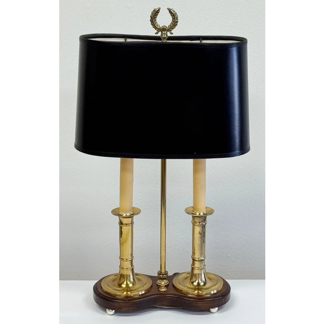 Vintage French Bouillotte style lamp with a wood base and brass overlay. Two candle sticks topped with black oval shade....