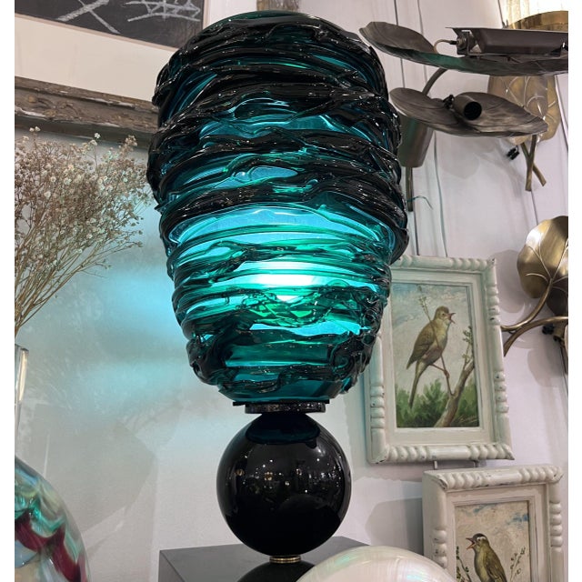 Table lamp consisting of a square, black Murano glass base with a brass finial. A central stem has been added to this...