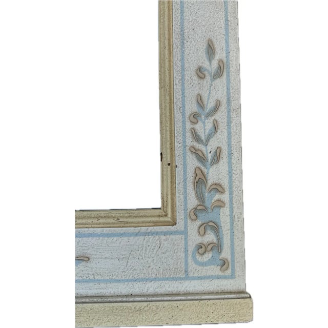 A vintage Widdicomb Regency style wood wall mirror. In an antiqued ivory finish with raised painted floral design in light...