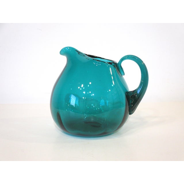 A nine piece hand blown green toned glass ware set with pitcher and mugs by iconic Mid Century glass designer Wayne Husted...