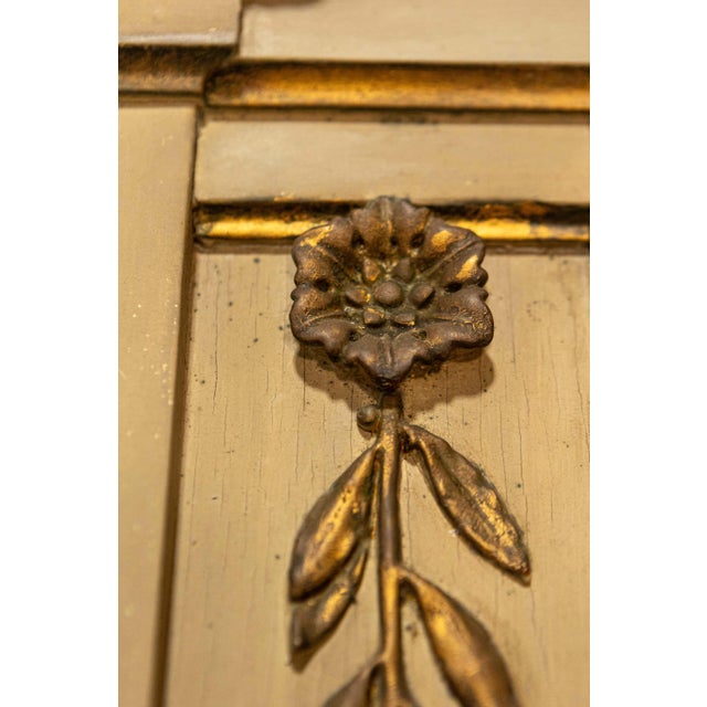 A French Empire style beige painted trumeau mirror from the 20th century with gilded décor. This exquisite French Empire...