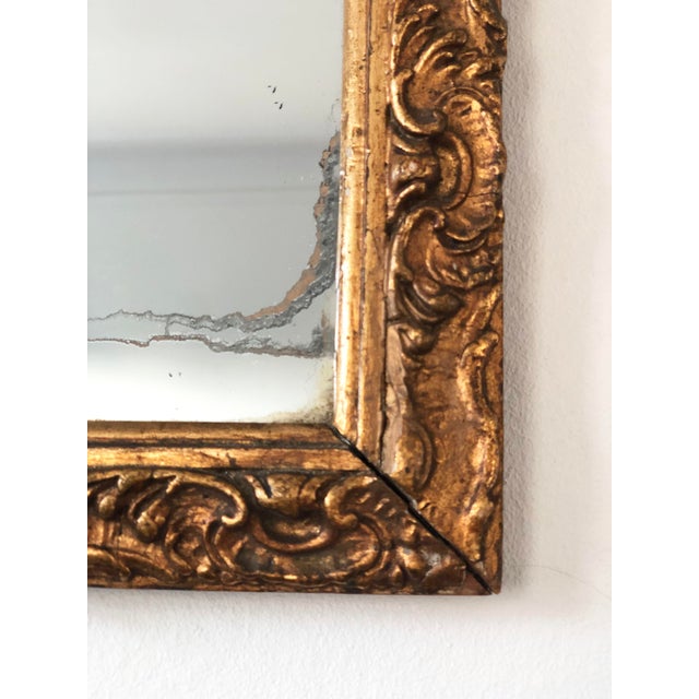 Antique small full-length wall mirror with a hand-carved giltwood frame, made in Belgium around 1900. The design shows...