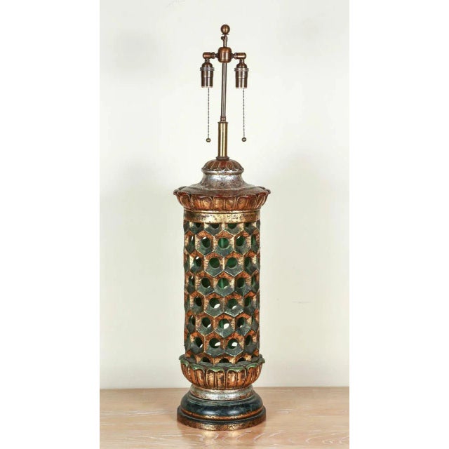 Very grand ceramic table lamp. The body of the lamp is pierced and the base and cap have vaguely lotus style moldings. The...