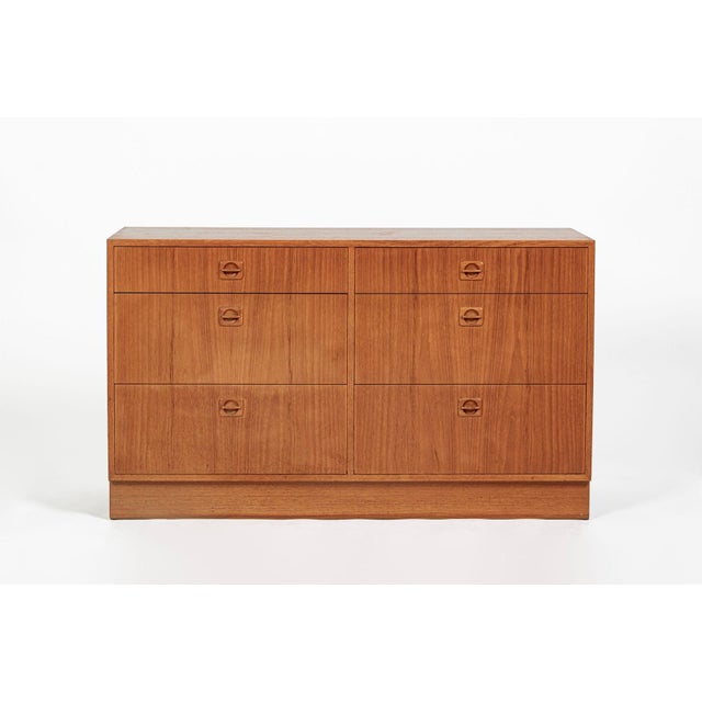 This vintage Danish mid-century modern six-drawer dresser or chest was produced circa 1960 and features warm teak veneer...