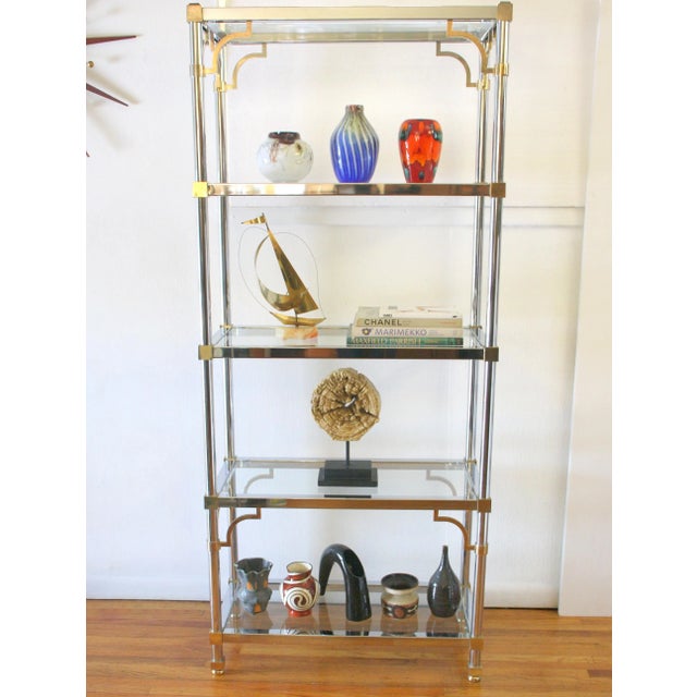 This is a mid century modern Maison Jansen style shelving unit. It has a beautiful chrome frame with brass accents, and...