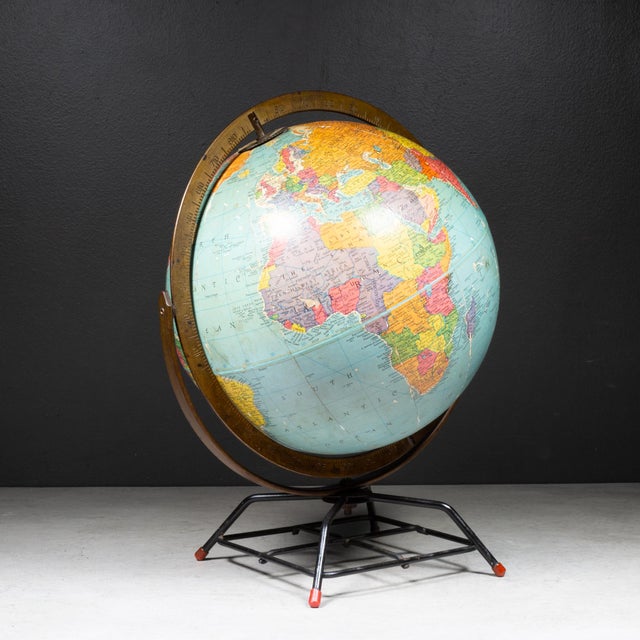 ABOUT A mid-century modern 10-inch Replogle world globe featuring a brass-plated meridian ring and bracket and industrial...