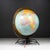 ABOUT A mid-century modern 10-inch Replogle world globe featuring a brass-plated meridian ring and bracket and industrial...