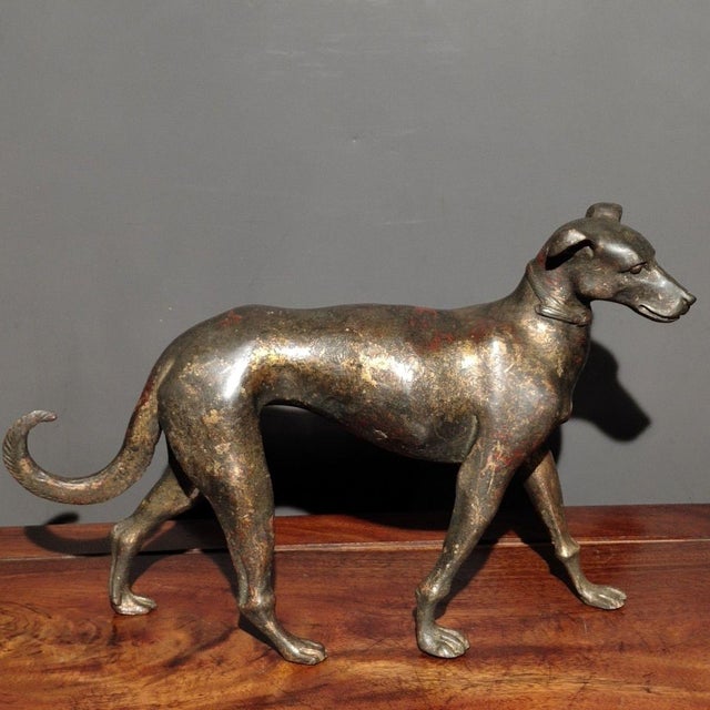 This charming antique gilt bronze figurine depicts a standing dog, a traditional symbol of loyalty, protection, and good...