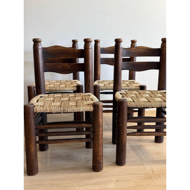 A beautifully preserved set of four original unmarked Charles Dudouyt rush chairs, showcasing the designer’s signature...