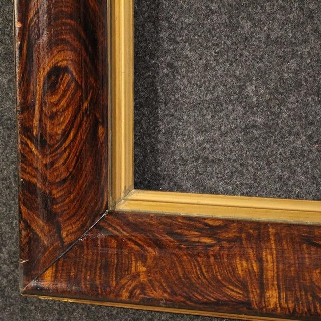 Mid-20th-century Italian frame. Carved, lacquered, gilded (bronze tint), and painted wooden piece with a faux wood finish....