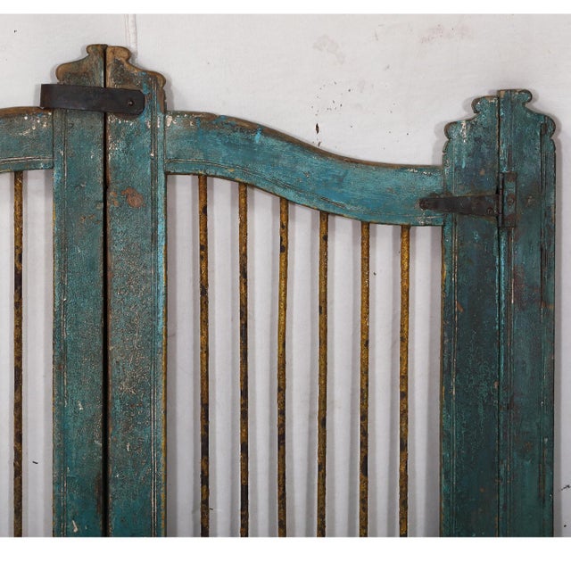 Called a "dog door" in India, this arched top gate with iron security rods above a paneled base, has shaped center and...