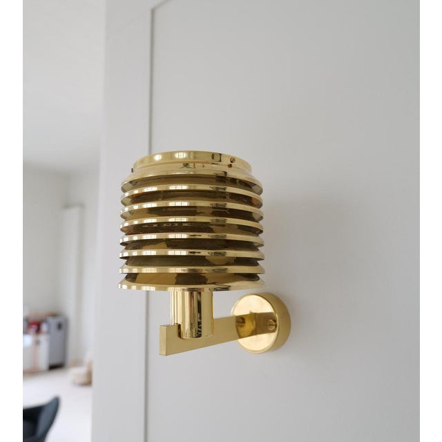 A stunning pair of wall mounted lamps with base and laminated shade in brass. Vintage condition, with wear on the brass....