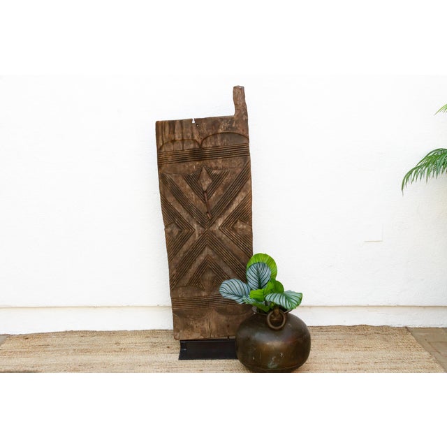 Hand-carved from a single plank of hardwood, this door carries the geometric vocabulary of Mali's Dogon and Bamana doors —...