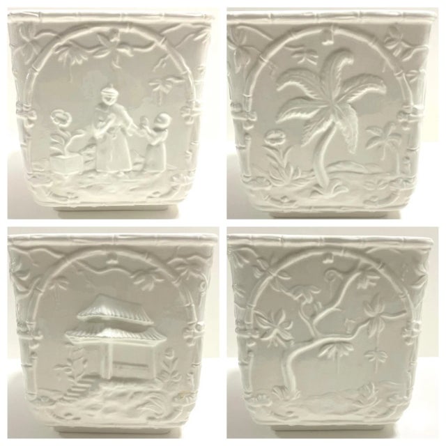 A refined Mottahedeh “Musee Des Arts” porcelain cachepot planter featuring sculptural blanc de chine relief scenes...
