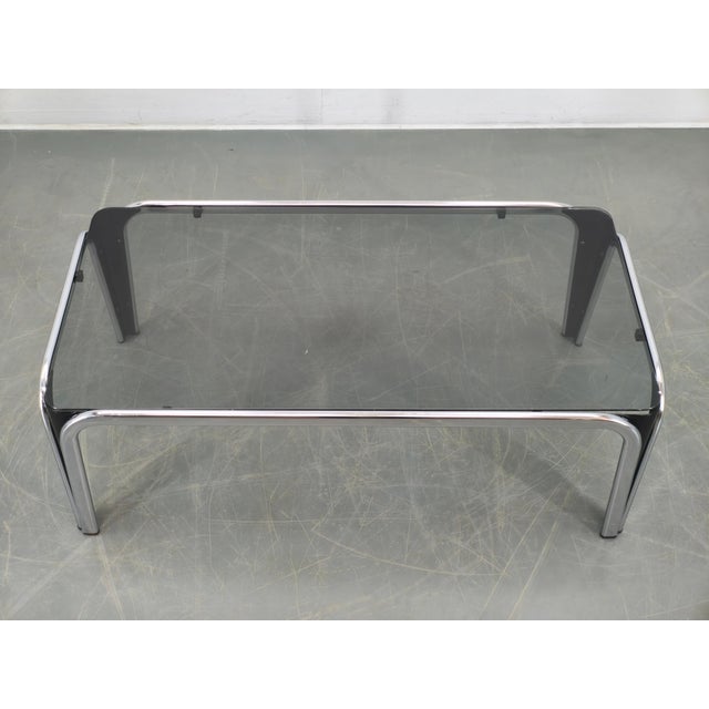 This piece features a sleek chrome-plated metal frame combined with black lacquered structural elements and a smoked glass...