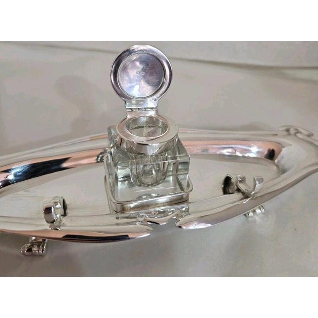 A fine george v sterling silver inkwell standish dating to the early 20th century, displaying the elegant flowing...