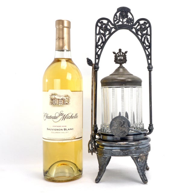 An over-the top Aesthetic Movement pickle caster with Japanese fan adornments. The frame finial shows floral motifs. The...