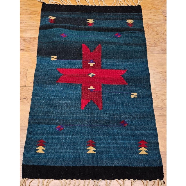 This vintage American Southwestern kilim rug, handwoven in the late 20th century, beautifully captures the essence of...
