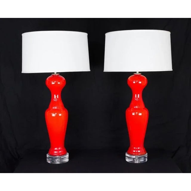 Italian 1950s Murano pawn-shaped glass lamps in a brilliant red-orange, on new plexiglass bases with grey twisted cords....