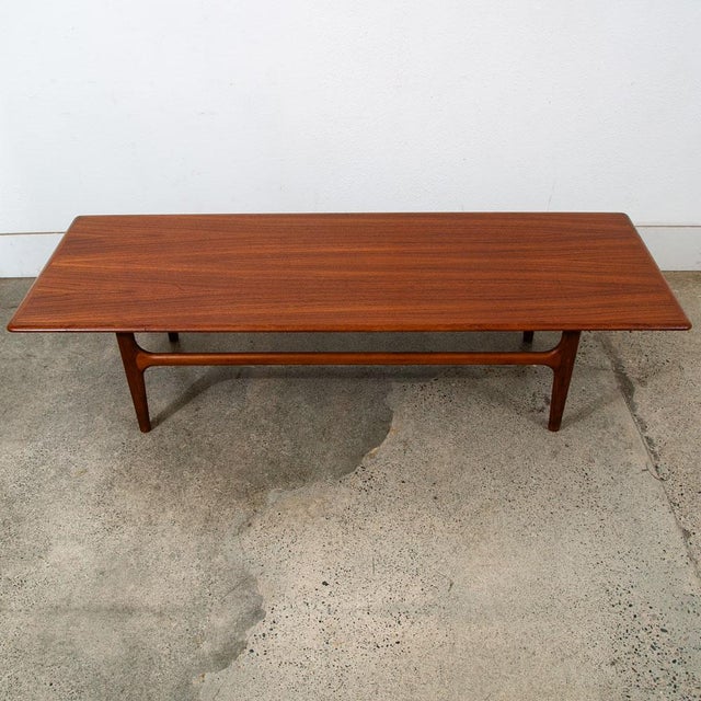 Solid teak Danish modern surfboard coffee table. The solid teak and teak veneer top surface sits upon 4 solid teak tapered...
