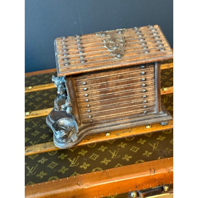 This cigar box is crafted in the form of a rustic wooden chalet, with detailed carvings that mimic wooden planks and...