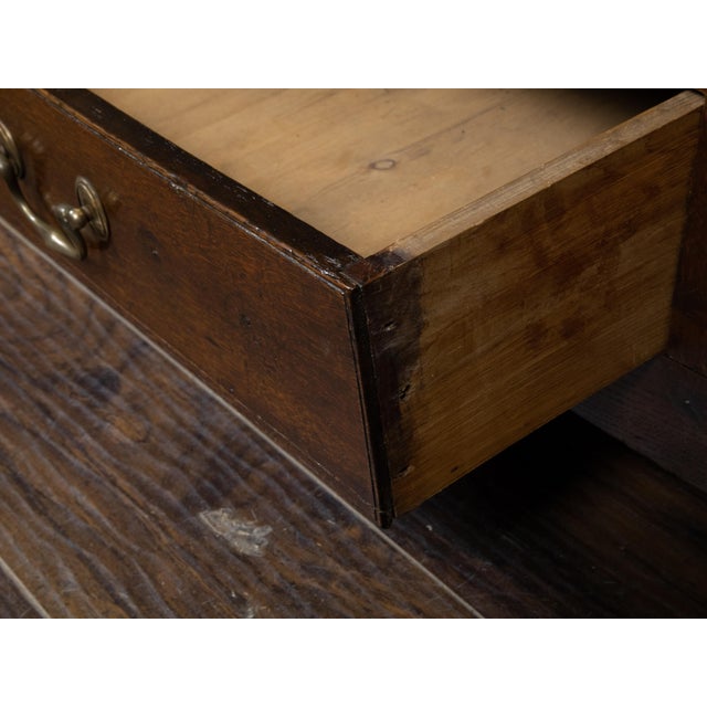 An English Georgian period oak buffet from the 18th century, with single central door, two drawers, carved arching motifs...
