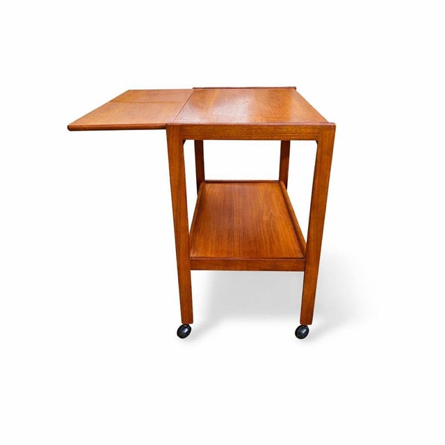 beautifully proportioned vintage teak drinks trolley, combining classic mid-century styling with practical versatility....