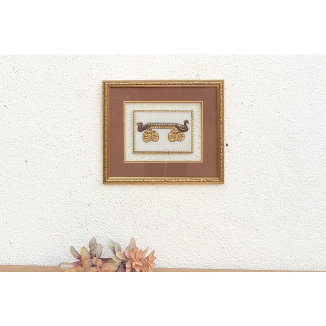 This painting showcases a unique object—a stylized musical instrument resembling a Sitar component adorned with peacock...