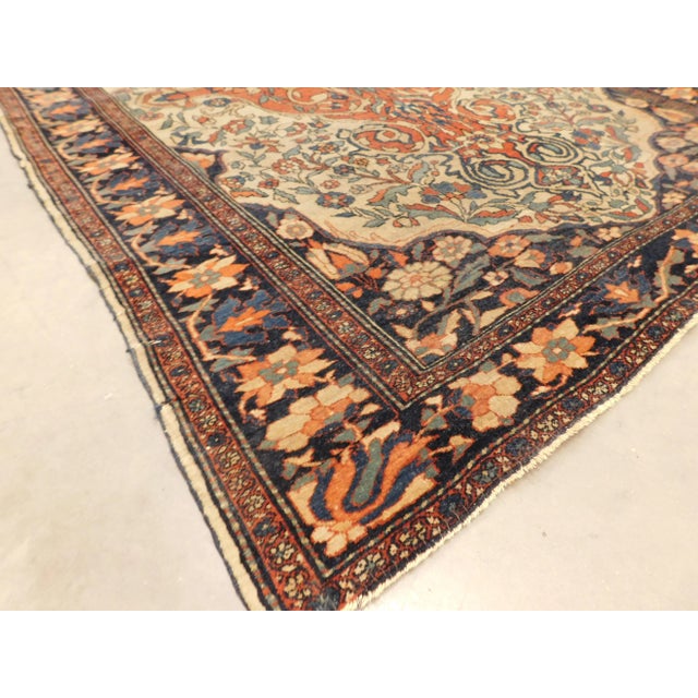 Elongated central medallion on a floral decorated beige field, within blue border.