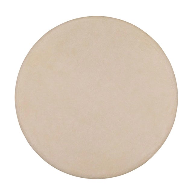 Minimalist round outdoor coffee table with a sculptural sloped pedestal base and round top, creating a calm, architectural...